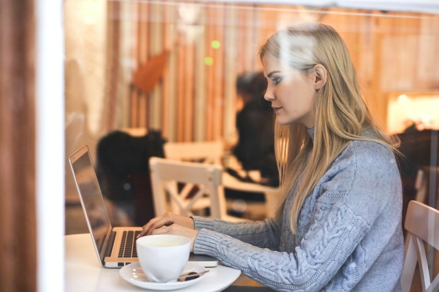 Ilustrasi perempuan sedang serius menggunakan laptop di cafe/Foto: Pexels/Andrea Piacquadio