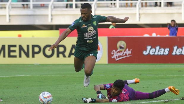 Pesepak bola Persebaya Paulo Victor Costa Soares (kiri) berusaha menendang bola yang coba dihalau penjaga gawang Rans Nusantara FC Hilman Syah (kanan) saat pertandingan Liga 1 di Stadion Gelora Bung Tomo, Surabaya, Jawa Timur, Minggu (23/7/2023). Persebaya bermain imbang melawan Rans Nusantara FC dengan skor akhir 2-2. ANTARA FOTO/Moch Asim/nz