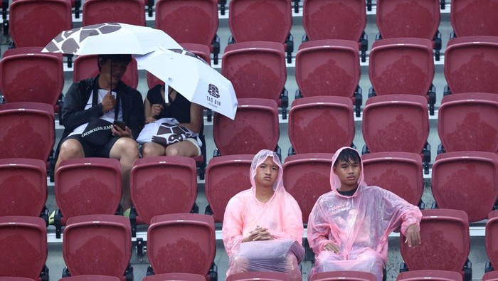 Tottenham Vs Leicester di Rajamangala Soccer Football - Pre Season Friendly - Leicester City v Tottenham Hotspur - Rajamangala National Stadium, Bangkok, Thailand - July 23, 2023 Fans in rain coats inside the stadium as the match is cancelled due to bad weather REUTERS/Athit Perawongmetha
