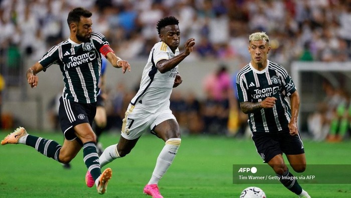HOUSTON, TEXAS - JULY 26: Vinicius Jnior #7 of Real Madrid dribbles the ball between Bruno Fernandes #8 of Manchester United and Lisandro Martinez #6 in the first half during the 2023 Soccer Champions Tour match at NRG Stadium on July 26, 2023 in Houston, Texas.   Tim Warner/Getty Images/AFP (Photo by Tim Warner / GETTY IMAGES NORTH AMERICA / Getty Images via AFP)