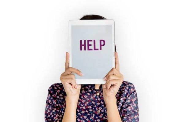 Perempuan memegang tulisan help di wajahnyan