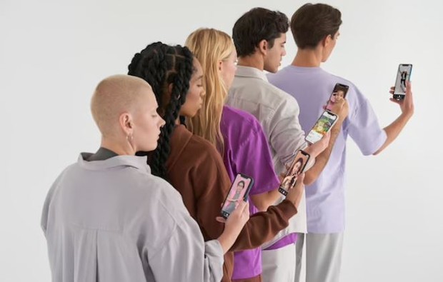 Empat orang sedang melihat handphonenya