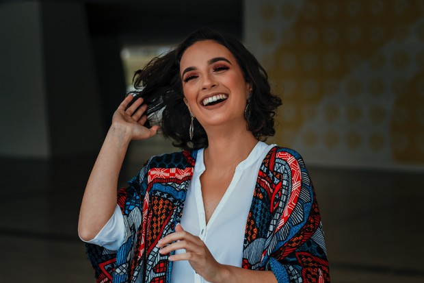 Illustration of a woman tossing her hair and smiling/Photo: Pexels/Vinicius wiesehofer