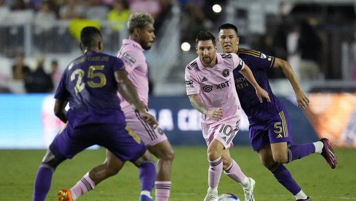 Inter Miami forward Lionel Messi (10) watches as forward Josef Martínez controls the ball, pursued by Orlando City midfielder César Araújo (5) and defender Antonio Carlos (25), during the second half of a Leagues Cup soccer match Wednesday, Aug. 2, 2023, in Fort Lauderdale, Fla. (AP Photo/Rebecca Blackwell)