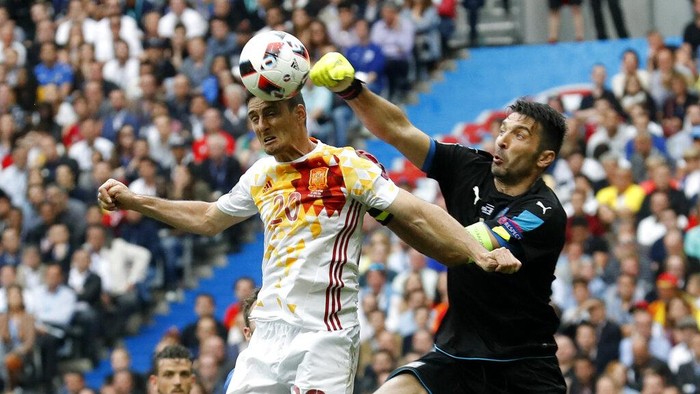 Melihat Lagi Aksi-aksi Buffon di Bawah Mistar Gawang Italy goalkeeper Gianluigi Buffon clears the ball ahead of Spain's Aritz Aduriz during the Euro 2016 round of 16 soccer match between Italy and Spain, at the Stade de France, in Saint-Denis, north of Paris, Monday, June 27, 2016. (AP Photo/Antonio Calanni)