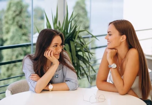 Dua perempuan sedang mengobrol