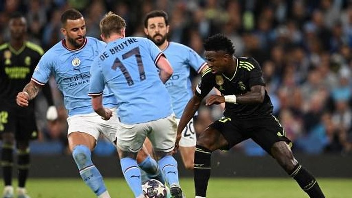 Real Madrids Brazilian forward Vinicius Junior (R) vies Manchester Citys English defender Kyle Walker (L), Manchester Citys Belgian midfielder Kevin De Bruyne (2L) and Manchester Citys Portuguese midfielder Bernardo Silva with  during the UEFA Champions League second leg semi-final football match between Manchester City and Real Madrid at the Etihad Stadium in Manchester, north west England, on May 17, 2023. (Photo by Paul ELLIS / AFP)