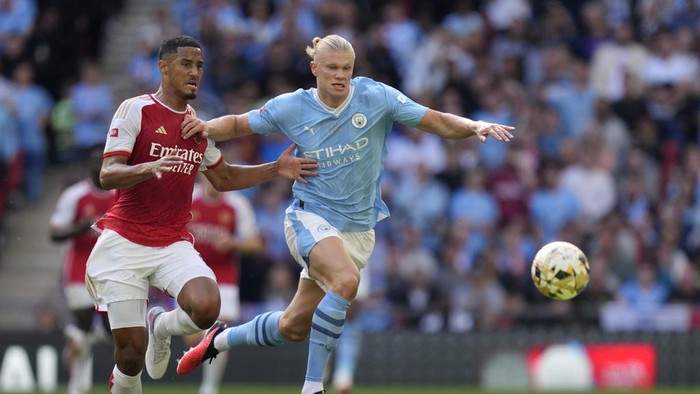 Arsenals William Saliba, left, challenges for the ball with Manchester Citys Erling Haaland during the English FA Community Shield final soccer match between Arsenal and Manchester City at Wembley Stadium in London, Sunday, Aug. 6, 2023. (AP Photo/Kirsty Wigglesworth)