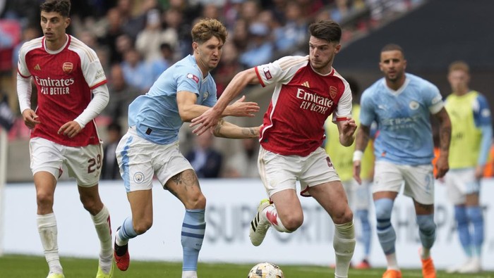 Manchester Citys John Stones, second left, challenges for the ball with Arsenals Declan Rice during the English FA Community Shield final soccer match between Arsenal and Manchester City at Wembley Stadium in London, Sunday, Aug. 6, 2023. (AP Photo/Kirsty Wigglesworth)