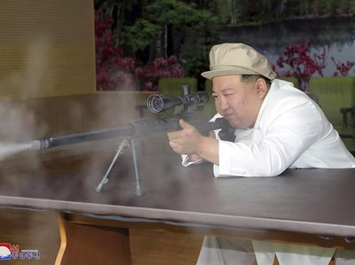 Gaya Kim Jong Un Uji Senapan Saat Inspeksi Pabrik Senjata