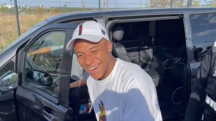 A video image grab shows Paris Saint-Germains forward Kylian Mbappe as he stops at the entrance of the Paris Saint-Germain training grounds to meet with fans and sign autographs, after a training session in Poissy, western suburbs of Paris, on July 22, 2023. Kylian Mbappe signed autographs and took selfies with club supporters after a training session with PSG reserve players on July 22, less than 24 hours after the club left him out of their squad for a pre-season tour of Japan and South Korea. PSG gave no reason for the omission of Frances captain but 24-year-old Mbappe has said for weeks that he is refusing to sign a new contract. (Photo by Tom MASSON / AFP)