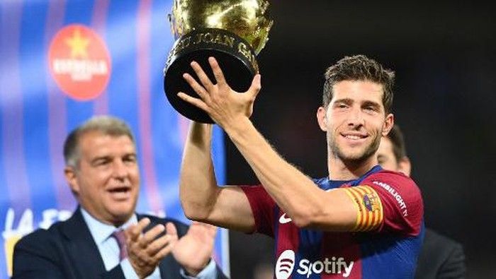 Barcelonas Spanish midfielder #20 Sergi Roberto raises the winners trophy after the 58th Joan Gamper Trophy football match between FC Barcelona and Tottenham Hotspur FC at the Estadi Olimpic Lluis Companys in Barcelona on August 8, 2023. (Photo by Pau BARRENA / AFP)