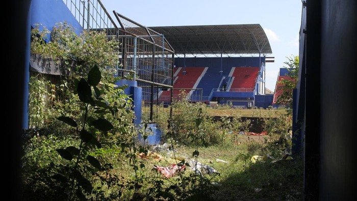 Semak liar tumbuh dan menutupi area lapangan sepak bola di Stadion Kanjuruhan, Malang, Jawa Timur, Rabu (9/8/2023). Sejak peristiwa tragedi Kanjuruhan, lapangan sepak bola tersebut tidak pernah digunakan lagi sehingga tak terawat serta ditumbuhi semak liar sementara itu waktu pelaksanaan renovasi hingga kini belum ada kepastian. ANTARA FOTO/Ari Bowo Sucipto/aww.