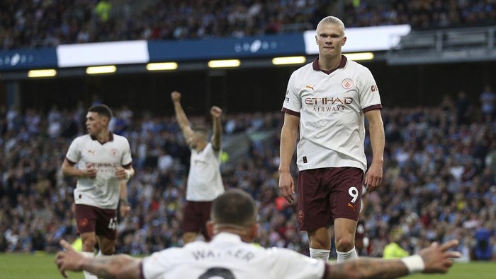 Manchester Citys Erling Haaland celebrates scoring their sides second goal of the game with team-mate Kyle Walker during the Premier League soccer match between Manchester City and Burnley FC at Turf Moor, Burnley, England, Friday Aug. 11, 2023. (Nigel French/PA via AP)