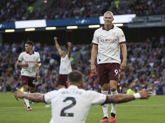 Manchester Citys Erling Haaland celebrates scoring their sides second goal of the game with team-mate Kyle Walker during the Premier League soccer match between Manchester City and Burnley FC at Turf Moor, Burnley, England, Friday Aug. 11, 2023. (Nigel French/PA via AP)