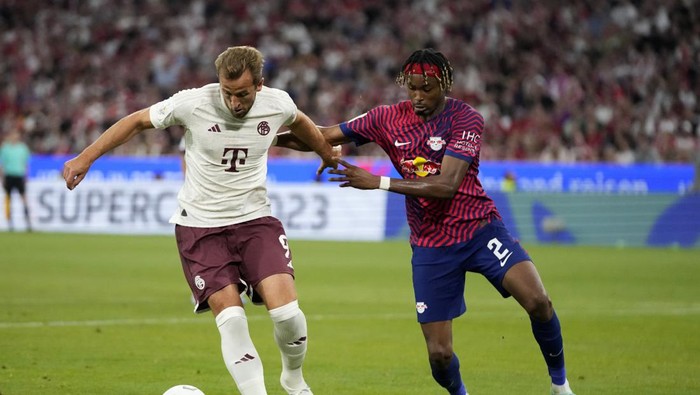 Leipzigs Mohamed Simakan, right, challenges Bayerns Harry Kane during the German Super Cup final between FC Bayern Munich and RB Leipzig at the Allianz Arena stadium in Munich, Germany, Saturday, Aug. 12, 2023. (AP Photo/Matthias Schrader)