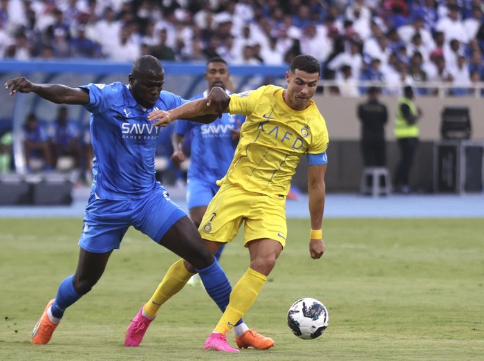Al-Nassrs Cristiano Ronaldo, right, fights for the ball against Al-Hilals Kalidou Koulibaly during the Arab Club Champions Cup between Al-Nassr and Al-Hilal at King Fahd Stadium in Taif, Saudi Arabia, Saturday, Aug. 12, 2023. (AP Photo/Samah Zidan)