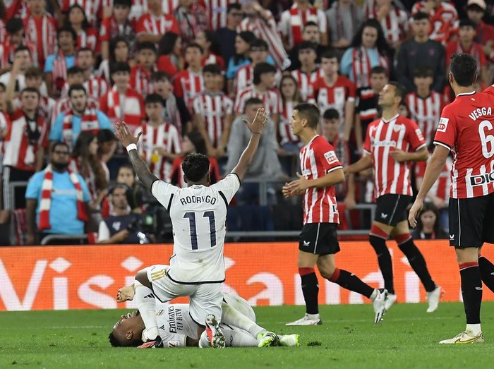 Real Madrids Rodrygo, centre, gestures as Eder Militao, bottom, lies on the pitch in pain during the Spanish La Liga soccer match between Athletic Club and Real Madrid at the San Mames stadium in Bilbao, Spain, Saturday, Aug. 12, 2023. (AP Photo/Alvaro Barrientos)