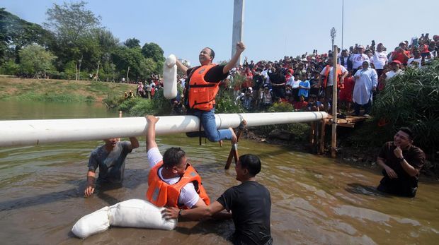 Bakal calon presiden dari Koalisi Perubahan Anies Baswedan (kanan) meluapkan kegembiraannya usai memenangi lomba gebuk bantal melawan perwakilan warga di Waduk Lebak Bulus, Cilandak, Jakarta Selatan, Kamis (17/8/2023). Anies Baswedan mengikuti perlombaan tarik tambang dan gebuk bantal bersama warga sekitar guna menyemarakkan peringatan HUT ke-78 Kemerdekaan RI. ANTARA FOTO/Indrianto Eko Suwarso/hp.