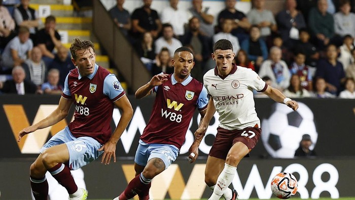 Soccer Football - Premier League - Burnley v Manchester City - Turf Moor, Burnley, Britain - August 11, 2023 Manchester Citys Phil Foden in action with Burnleys Sander Berge and Vitinho Action Images via Reuters/Jason Cairnduff EDITORIAL USE ONLY. No use with unauthorized audio, video, data, fixture lists, club/league logos or live services. Online in-match use limited to 75 images, no video emulation. No use in betting, games or single club /league/player publications.  Please contact your account representative for further details.