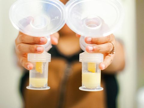 A mother proudly showing off the collection of breast milk from pumping.