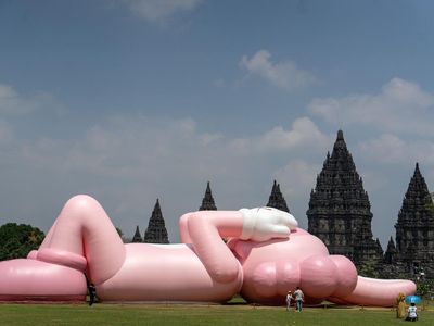 Potret Boneka Raksasa KAWS Rebahan di Candi Prambanan