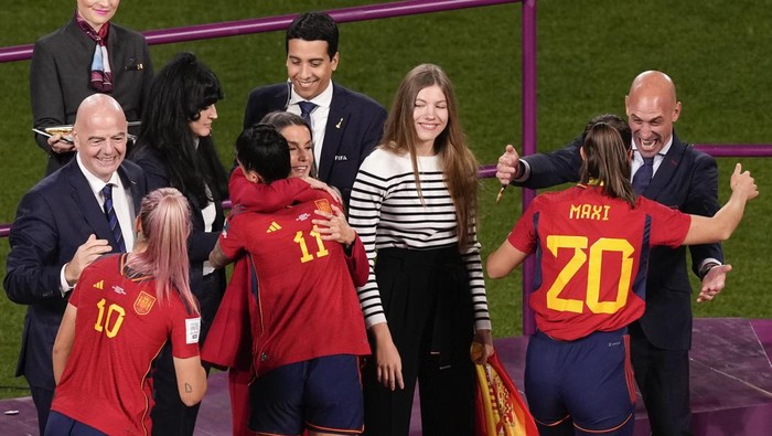 President of Spains soccer federation, Luis Rubiales, right, reacts as he greets Rocio Galvez on the podium following Spains win in the final of Womens World Cup soccer against England at Stadium Australia in Sydney, Australia, Sunday, Aug. 20, 2023. Pictured from left, is FIFA President Gianni Infantino with Spains Jennifer Hermoso, Spains Alexia Putellas is embraced by Queen Letizia of Spain as Princess Infanta Sofia watches. (AP Photo/Mark Baker)