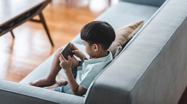 Chinese boy using smart phone in the living room