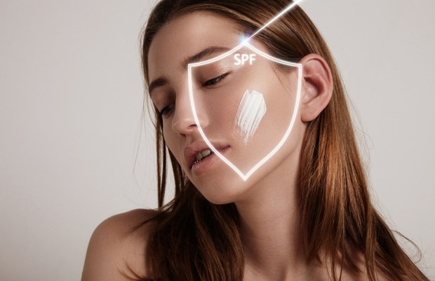 Foto perempuan yang menggunakan sunscreen.