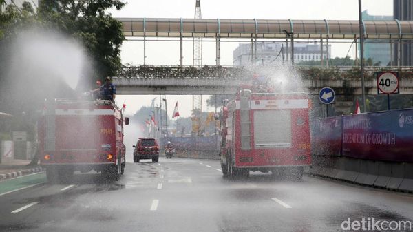 Kurangi Polusi Udara, Pemadam Kebakaran Semprotkan Air ke Jalan
