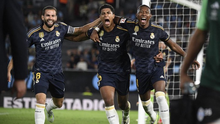 Real Madrid's English midfielder #5 Jude Bellingham (C) celebrates his goal with Real Madrid's Spanish defender #06 Nacho Fernandez and Real Madrid's Austrian defender #04 David Alaba during the Spanish Liga football match between RC Celta de Vigo and Real Madrid CF at the Balaidos stadium in Vigo on August 25, 2023. (Photo by MIGUEL RIOPA / AFP)