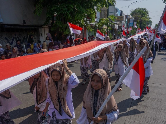 Ulama Habib Muhammad Luthfi bin Ali bin Yahya yang juga sekaligus ketua World Sufi Assembly (kedua kanan, bawah) didampingi Walikota Pekalongan Afzan Arslan Djunaid (kedua kiri, atas) menyapa warga di saat mengikuti Kirab Merah Putih di Pekalongan, Jawa Tengah, Senin (28/8/2023). Kirab merah putih dalam rangka menyambut Muktamar Sufi Internasional atay World Sufi Assembly Conference 2023 itu dibarengi sekitar 2.000 penerima yang berisikan Forkopimda, Tentara Nasional Indonesia dan Polri, organisasi penduduk  serta pelajar dengan menenteng bendera sepanjang 1.001 meter yang rencananya pada  muktamar tersebut akan didatangi oleh Presiden Joko Widodo pada Selasa (29/8). ANTARA FOTO/Harviyan Perdana Putra/hp.