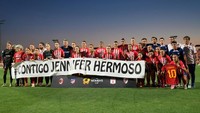 Para pemain tim putri Atletico, dan staf, memamerkan spanduk dukungan kepada Jenni sebelum laga melawan AC Milan. Foto: Handout via REUTERS/HANDOUT