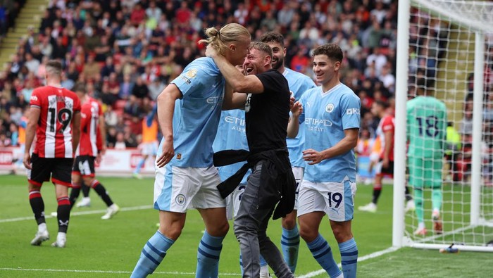 Soccer Football - Premier League - Sheffield United v Manchester City - Bramall Lane, Sheffield, Britain - August 27, 2023 Manchester Citys Erling Braut Haaland celebrates scoring their first goal with teammates and a fan REUTERS/Phil Noble EDITORIAL USE ONLY. No use with unauthorized audio, video, data, fixture lists, club/league logos or live services. Online in-match use limited to 75 images, no video emulation. No use in betting, games or single club /league/player publications.  Please contact your account representative for further details.