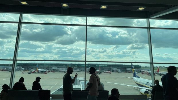 Passengers awaiting news on cancelled or delayed flights at London Stansted Airport gesture as they discuss the situation on Monday, in Stansted, Britain August 28, 2023. REUTERS/Raphael Satter   REFILE - CORRECTING CITY FROM LONDON TO STANSTED