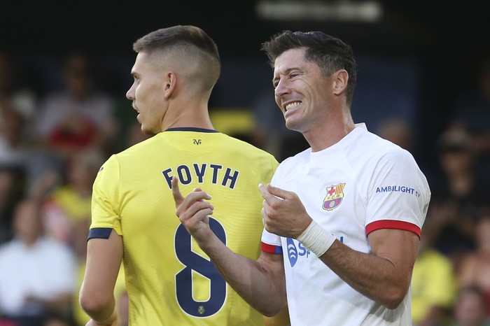 Barcelonas Robert Lewandowski, right, reacts next to Villarreals Juan Foyth during a Spanish La Liga soccer match between Villarreal and Barcelona at the Ceramica stadium in Villarreal, Spain, Sunday, Aug. 27, 2023. (AP Photo/Alberto Saiz)