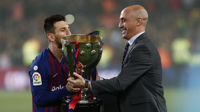 Barcelonas Argentinian forward Lionel Messi (L) receives the Liga trophy from Spanish Football Federation president Luis Rubiales after Barcelona won their 26th league title after the Spanish League football match between Barcelona and Levante at the Camp Nou stadium in Barcelona on April 27, 2019. (Photo by PAU BARRENA / AFP)