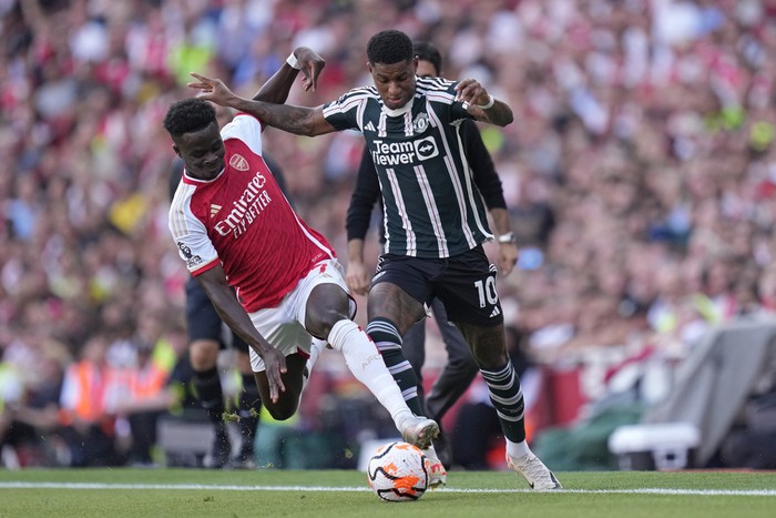 Arsenals Bukayo Saka, left, and Manchester Uniteds Marcus Rashford fight for the ball during the English Premier League soccer match between Arsenal and Manchester United at Emirates stadium in London, Sunday, Sept. 3, 2023. (AP Photo/Kirsty Wigglesworth)