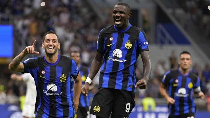 Inter Milans Hakan Calhanoglu, left, celebrates with Inter Milans Marcus Thuram after scoring his sides third goal during the Serie A soccer match between Inter Milan and Fiorentina at the San Siro Stadium, in Milan, Italy, Sunday, Sept. 3, 2023. (AP Photo/Antonio Calanni)