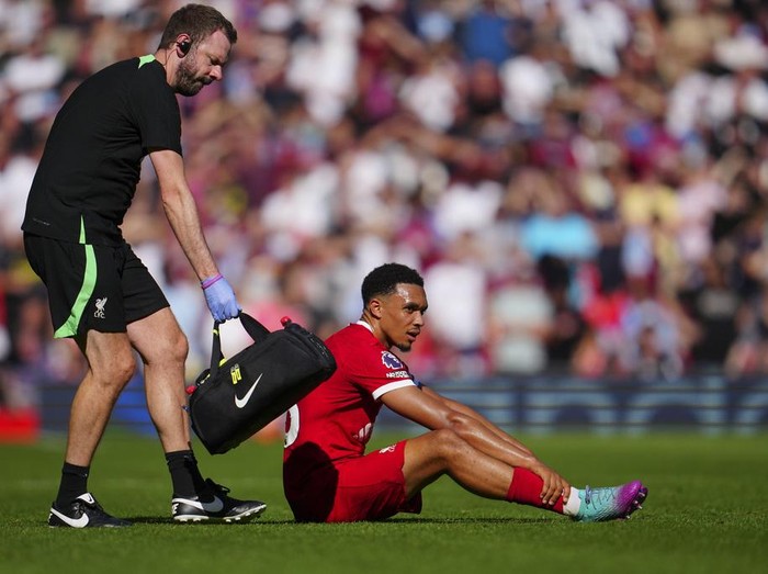 Liverpools Trent Alexander-Arnold sits on the pitch injured during the English Premier League soccer match between Liverpool and Aston Villa at Anfield stadium in Liverpool, Sunday, Sept. 3, 2023. (AP Photo/Jon Super)