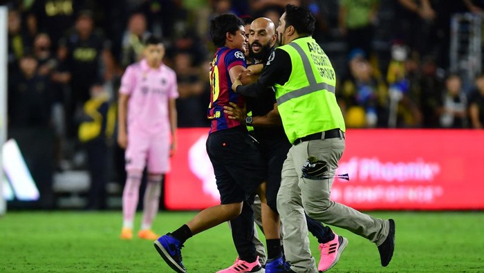 Sep 3, 2023; Los Angeles, California, USA; A young fan is intercepted by security after running onto the field to hug Inter Miami forward Lionel Messi (10) during the second half at BMO Stadium. Mandatory Credit: Gary A. Vasquez-USA TODAY Sports