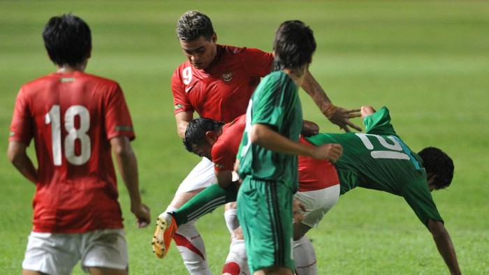 Hangeldiyev Guvanch (#21) of Turkmenistan battles for the ball with Firman Utina (C) and Christian Gonzales (#9) of Indoneisa during their 2014 World Cup Asian qualifying football match at the Gelora Bung Karno stadium in Jakarta on July 28, 2011. Indonesia beat Turkmenistan 4-3. AFP PHOTO / ADEK BERRY (Photo by ADEK BERRY / AFP)