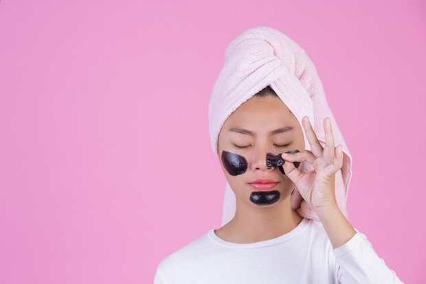 Mengaplikasikan masker peel off untuk mengatasi komedo/Foto: freepik.com/jcomp Foto perempuan sedang menggunakan masker peel off