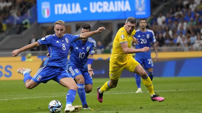 Italys Davide Frattesi, left, scores against Ukraine during the Euro 2024 group C qualifying soccer match between Italy and Ukraine at San Siro Stadium, in Milan, Italy, Tuesday, Sept.12, 2023. (AP Photo/Antonio Calanni)