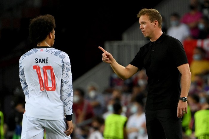 Bayern Munichs German midfielder Leroy Sane listens to Bayern Munichs German head coach Julian Nagelsmann (R) during the UEFA Champions League first round group E football match between Barcelona and Bayern Munich at the Camp Nou stadium in Barcelona on September 14, 2021. (Photo by LLUIS GENE / AFP)