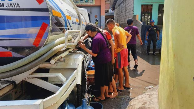 Warga RT 10 RW 11 Pegadungan, Kecamatan Kalideres, Jakarta Barat terlihat berbondong-bondong membawa ember dan jerigen untuk menampung air bersih ketika mobil pengangkut air Perusahaan Air Minum (PAM) Jaya tiba.