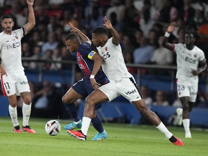 PSG's Kylian Mbappe, second from left, challenges for the ball with Nice's Jean-Clair Todibo during the French League One soccer match between Paris Saint Germain and Nice at Parc des Princes stadium in Paris, Friday, Sept. 15, 2023. (AP Photo/Michel Euler)
