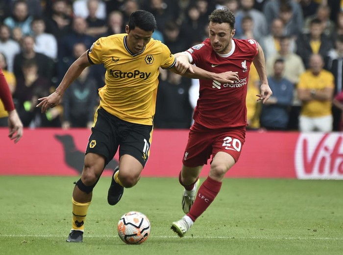 Wolverhampton Wanderers' Hwang Hee-chan, left, is challenged by Liverpool's Diogo Jota during the English Premier League soccer match between Wolverhampton and Liverpool at the Molineux stadium in Wolverhampton, England, Saturday, Sept. 16, 2023. (AP Photo/Rui Vieira)