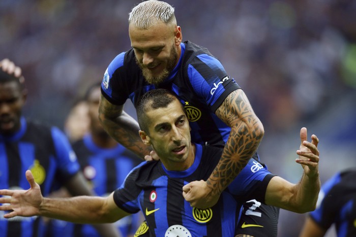 Inter Milan's Henrikh Mkhitaryan celebrates with teammate Federico Dimarco, top, after scoring the opening goal during a Serie A soccer match between Inter Milan and AC Milan at the San Siro stadium in Milan, Italy, Saturday, Sept.16, 2023. (Spada//LaPresse via AP)