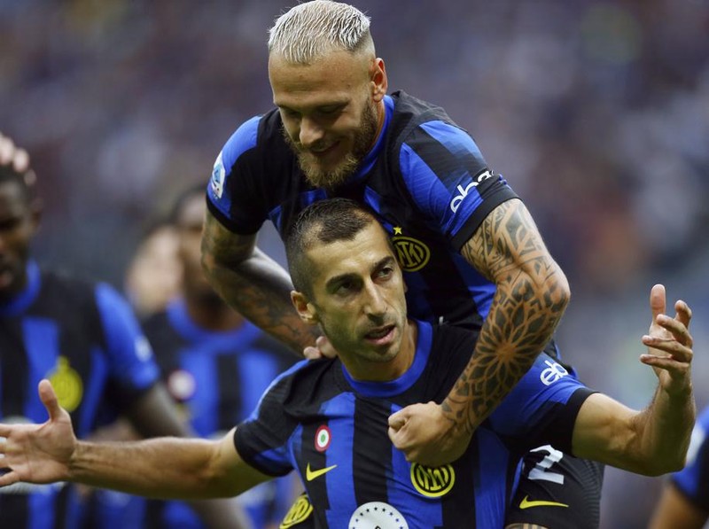 Inter Milan's Henrikh Mkhitaryan celebrates with teammate Federico Dimarco, top, after scoring the opening goal during a Serie A soccer match between Inter Milan and AC Milan at the San Siro stadium in Milan, Italy, Saturday, Sept.16, 2023. (Spada//LaPresse via AP)